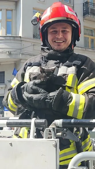 Pompier cu puiul salvat de pe acoperiș